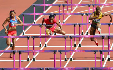 US Kellie Wells (C), Jamaica's Shermaine Williams (R) and Colombia's Lina Florez compete in the women's 100m hurdles heats at the athletics event of the London 2012 Olympic Games on August 6, 2012 in London. AFP PHOTO / GABRIEL BOUYS